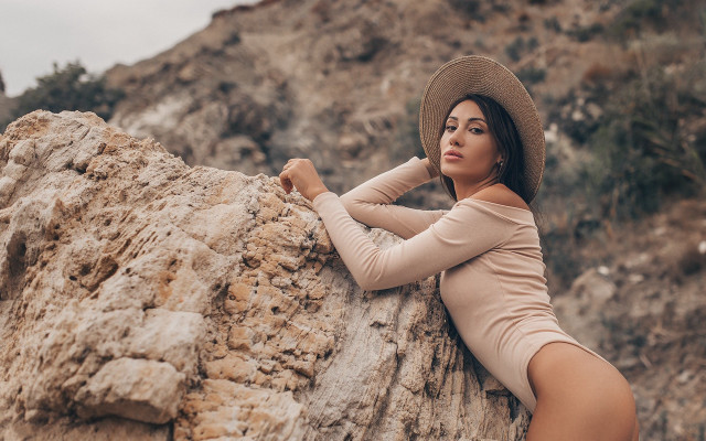 Woman hat leaning rock desert free wallpaper for desktop - medium preview image