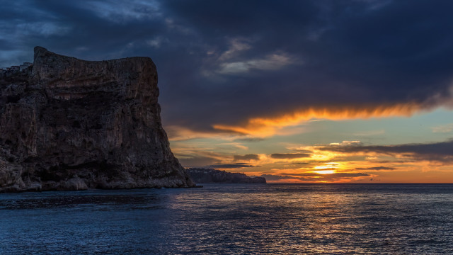 Rock outcropping sunset ocean boat free wallpaper for desktop - medium preview image