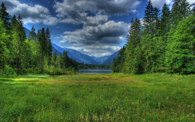 Grassy field lake mountains clouds free wallpaper for desktop - medium preview image