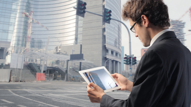 Man suit holding tablet city free wallpaper for desktop - medium preview image