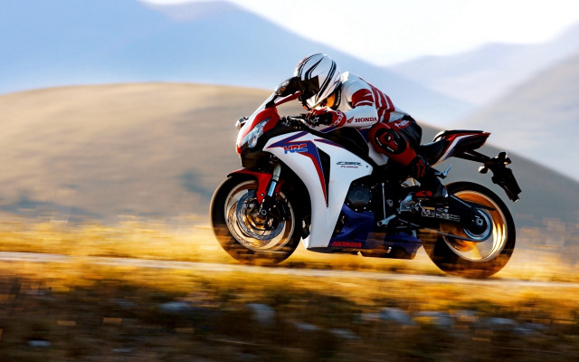 Motorcycle rider mountains grass blurry free wallpaper for desktop - medium preview image