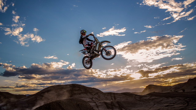 Motorcycle jump hill cloudy sky free wallpaper for desktop - medium preview image