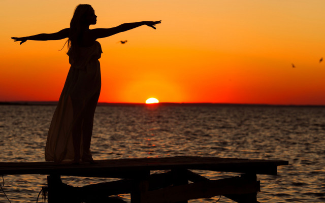 Woman dock sunset outstretched arms free wallpaper for desktop - medium preview image