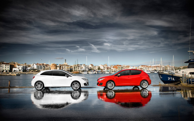 Two cars waterfront cityscape promotional free wallpaper for desktop - medium preview image