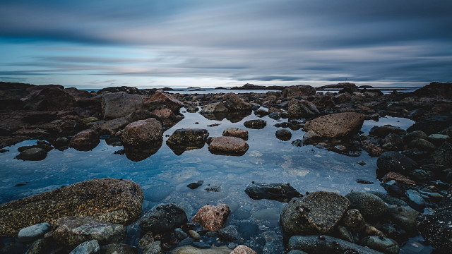 Rocky beach water boulders cloudy free wallpaper for desktop - medium preview image