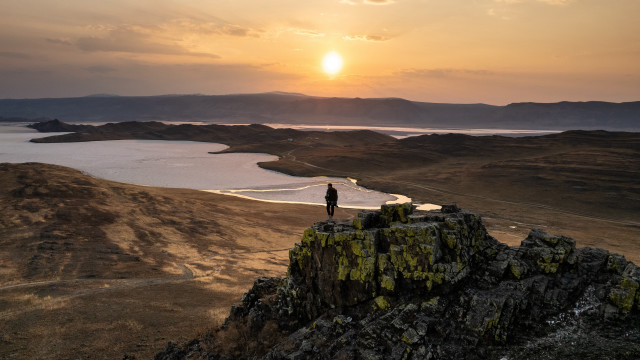 Person rock overlooking lake mountains free wallpaper for desktop - medium preview image