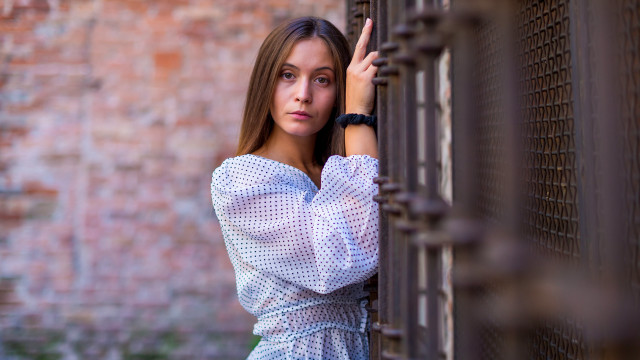 Woman fence serious portrait blurry free wallpaper for desktop - medium preview image