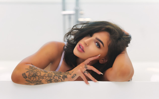 Tattooed woman leaning on wall free wallpaper for desktop - medium preview image