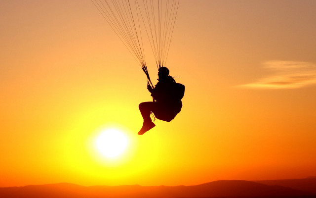Paragliding sunset mountain ocean silhouette free wallpaper for desktop - medium preview image