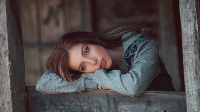 Woman leaning wooden ledge serious free wallpaper for desktop - medium preview image