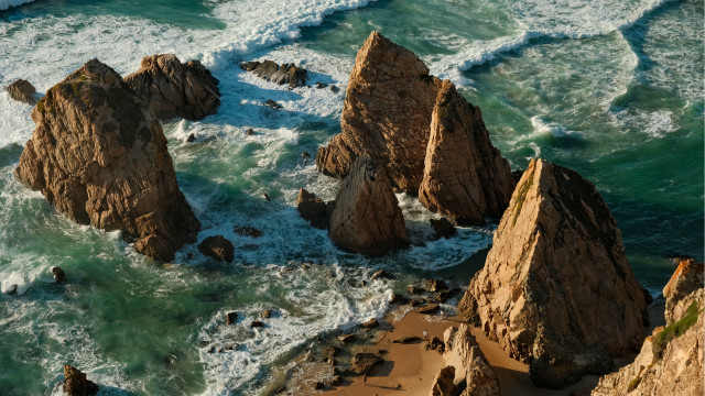 Rocky beach waves person cave free wallpaper for desktop - medium preview image