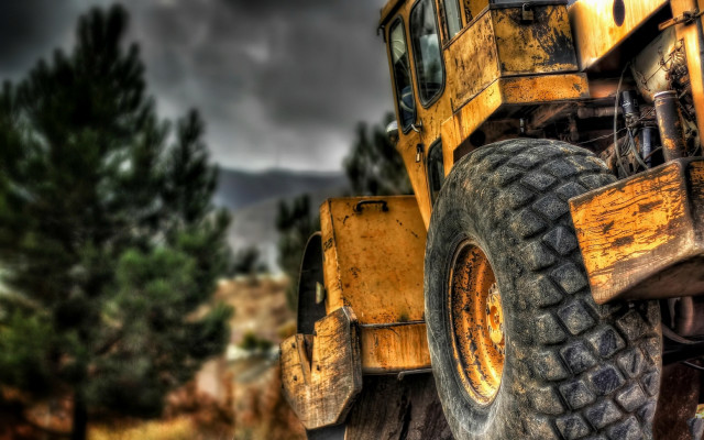 Yellow truck wooded area blurry free wallpaper for desktop - medium preview image