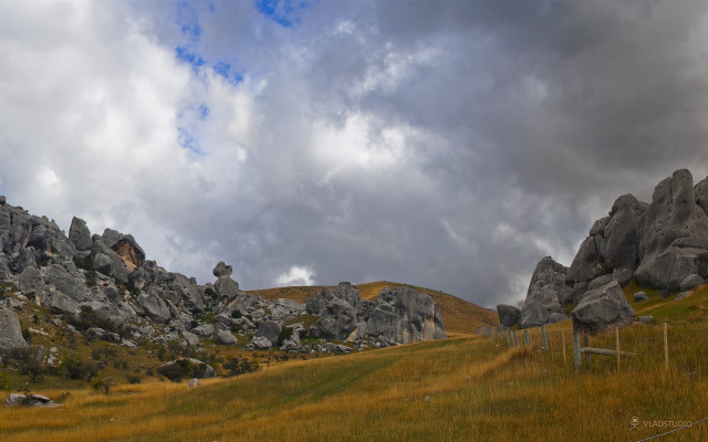 Grassy field rocks fence cloudy free wallpaper for desktop - medium preview image