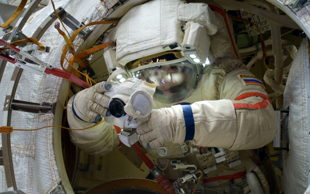 Space suit man holding device free wallpaper for desktop - medium preview image