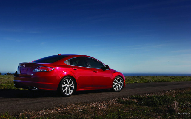 Red car ocean grass sunny free wallpaper for desktop - medium preview image
