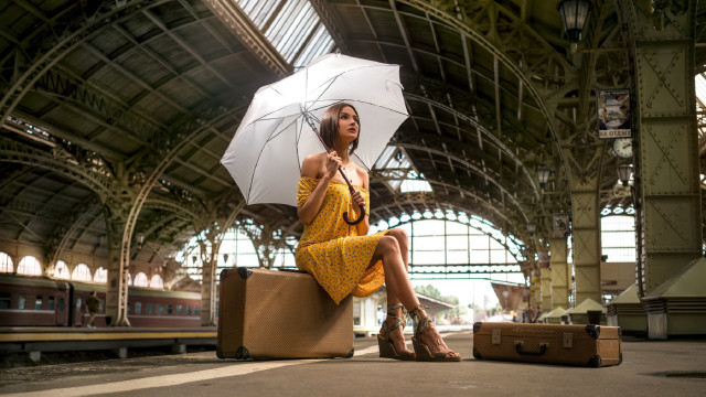 Woman sitting suitcase umbrella train free wallpaper for desktop - medium preview image