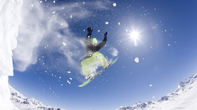 Snowboarder midair sunny mountains snowflakes free wallpaper for desktop - medium preview image