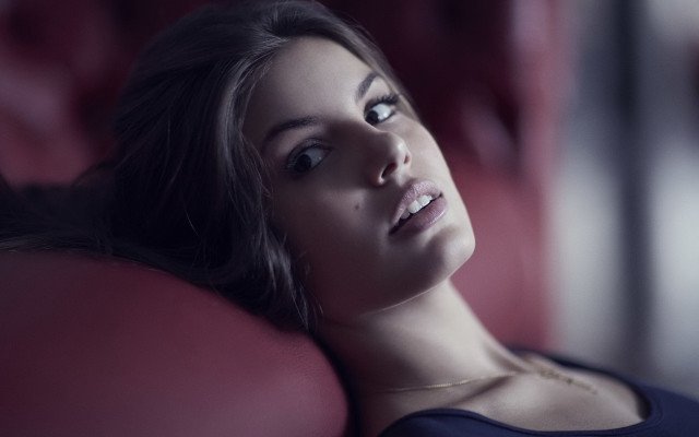 Woman laying red couch portrait free wallpaper for desktop - medium preview image