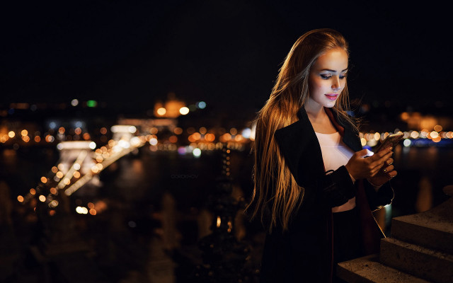 Woman ledge night city cellphone free wallpaper for desktop - medium preview image