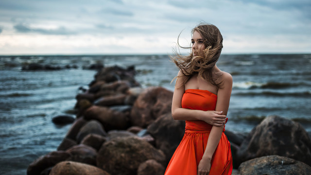 Woman orange dress ocean rocks free wallpaper for desktop - medium preview image