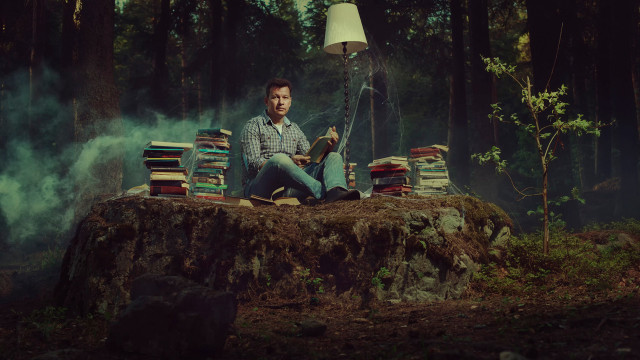 Man sitting pile books woods free wallpaper for desktop - medium preview image