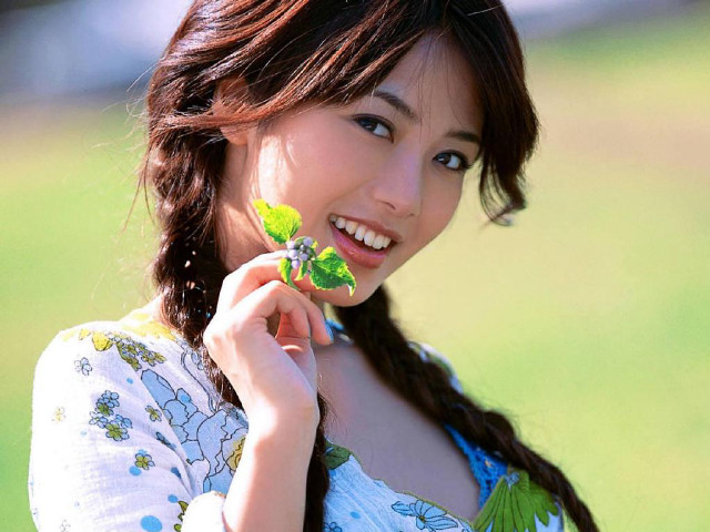 Woman holding leaf smiling green free wallpaper for desktop - medium preview image