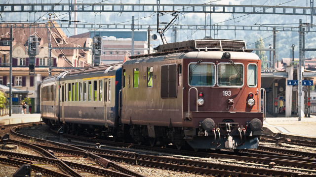 Train city buildings mountain tracks free wallpaper for desktop - medium preview image