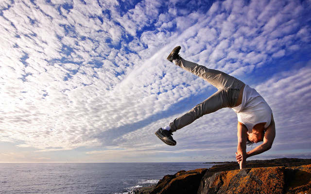 Man handstand rock ocean sky free wallpaper for desktop - medium preview image
