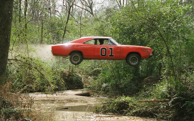 Red car jumping muddy stream free wallpaper for desktop - medium preview image