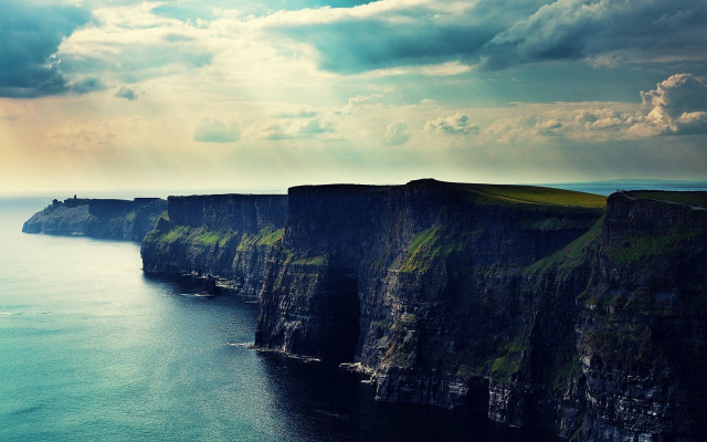 Cliff face water cloudy sky free wallpaper for desktop - medium preview image