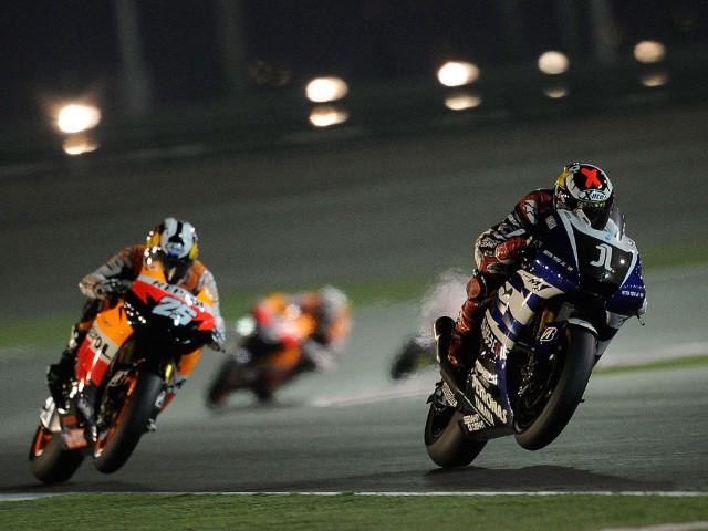 Three motorcyclists racing track nighttime free wallpaper for desktop - medium preview image