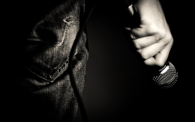 Person holding microphone black background free wallpaper for desktop - medium preview image