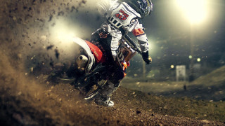 Man riding dirt bike night - a spotlight behind free wallpaper