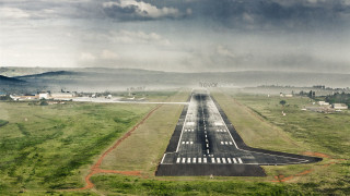 Runway plane field mountains cloudy - tilt shift free wallpaper