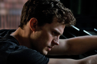 Man playing piano dark room - a brick wall behind free wallpaper