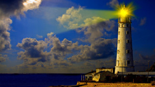 Lighthouse bright light ocean cloudy - yellow light free wallpaper