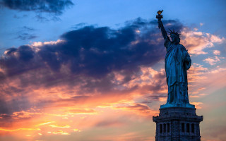 Statue liberty silhouette sunset sky - the background and a bird free wallpaper