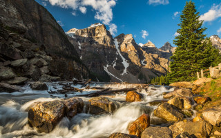 Mountain stream rocks trees background - the foreground and a mountain range in the background free wallpaper