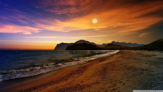 Beach sunset mountains water waves - the background and a body of water free wallpaper