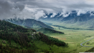 Valley winding road mountains cloudy - road in the middle of it free wallpaper
