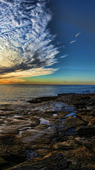 Rocky shore water clouds rocks - bascove free wallpaper for mobile