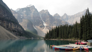 Canoes docked lake mountains snow - the mountain free wallpaper
