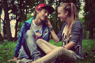 Boy girl sitting grass talking - each others eye free wallpaper