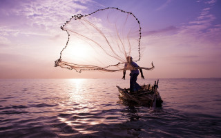 Woman boat net ocean sunset - the sun shining behind her free wallpaper