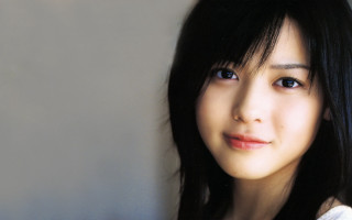 Woman black hair blue eyes 4 - a gray wall free wallpaper