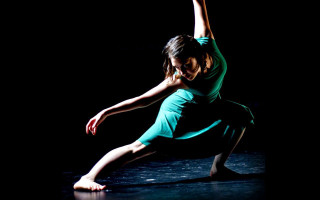 Woman green dress dance move - a black background behind her free wallpaper