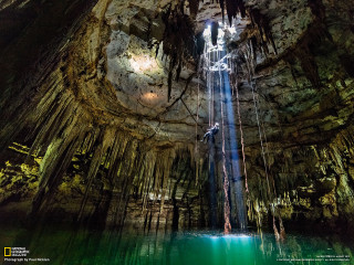 Man suspended rope cave waterfall - a light shining free wallpaper