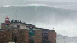 Crashing wave over building people - epic scale free wallpaper
