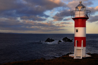 Red white lighthouse rocky shore - radiant free wallpaper