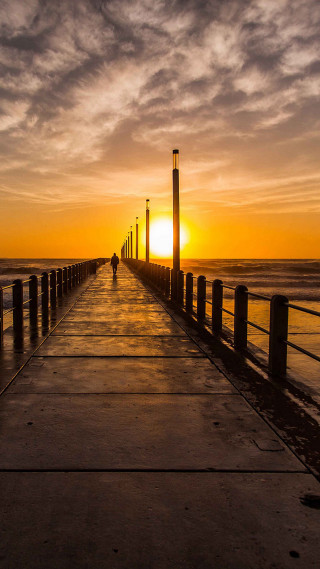 Person walking pier sunset ocean - free sunset wallpaper for mobile